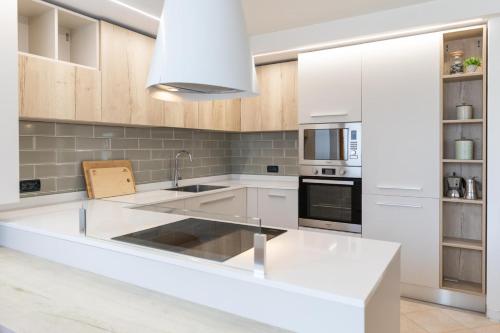 Una cocina con gabinetes blancos y una encimera blanca. en CASA BEBA - Agenzia Dolomiti Affitti, en Cavalese
