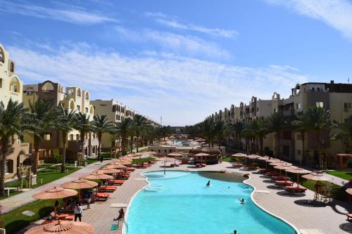 un complexe avec une piscine bordée de parasols dans l'établissement Comfortable studio in hotel 4 stars with private beach for non-egyptians only, à Hurghada