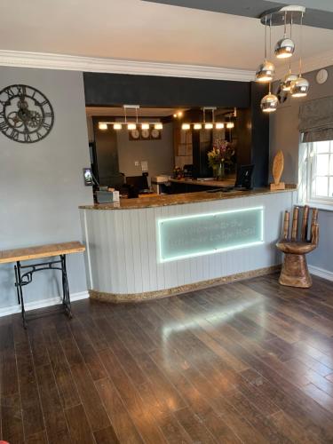 a restaurant with a counter and a bar in a room at Littleover Lodge Hotel in Derby