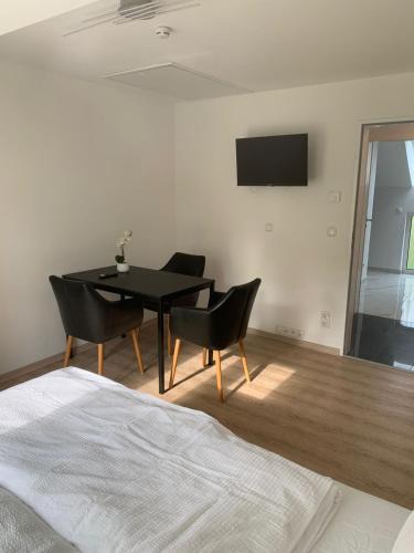 a dining room with a black table and chairs at AT-Rooms in Hannover