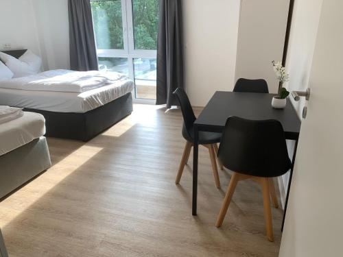 a bedroom with a table and chairs and a bed at AT-Rooms in Hannover