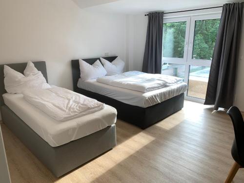 two beds in a room with a window at AT-Rooms in Hannover