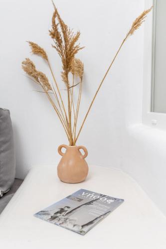 a vase sitting on a table with a magazine at Krina Mare Boutique Hotel in Naxos Chora