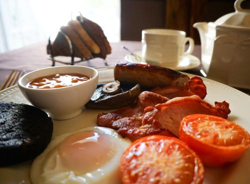 a table topped with plates of food and eggs at Manor House Hotel, Cockermouth in Cockermouth