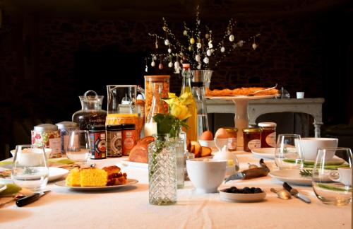 einen Tisch mit Teller mit Speisen und Weingläsern in der Unterkunft Au Relais de Laborde in Saint-Germain-les-Vergnes