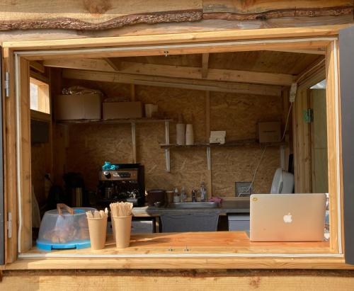 - une cuisine avec une table et un ordinateur portable dans l'établissement Bådsted Camping, à Gudhjem