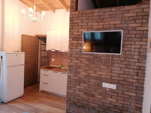 a kitchen with a brick wall with a tv on it at Tiny house by the sea in Nea Skioni