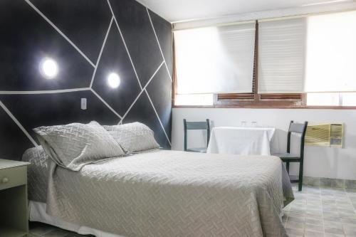 a bedroom with a bed and a black and white wall at Hotel Concorde in Arica