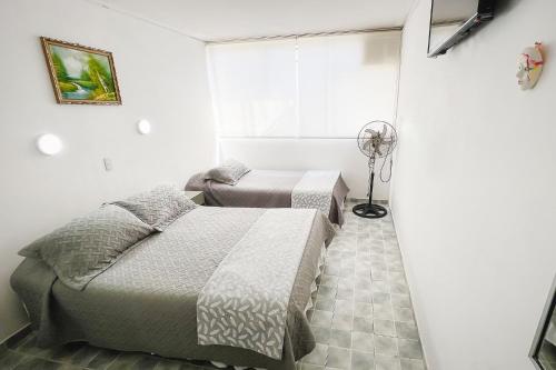 1 dormitorio con 2 camas y ventilador en Hotel Concorde en Arica