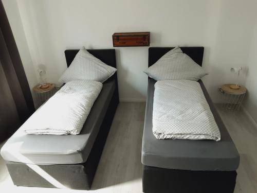 two beds with pillows on them in a room at Nordunterkunft in Neumünster