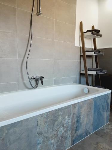 a bath tub with a faucet in a bathroom at Nordunterkunft in Neumünster