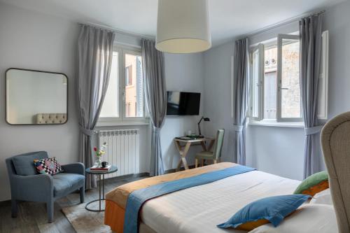 een slaapkamer met een bed, een stoel en ramen bij Now Apartments, ApartHotel in the heart of Rome in Rome