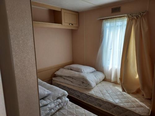 a small room with two beds and a window at 8 Berth The Chase Ingoldmells Sahara Super in Ingoldmells