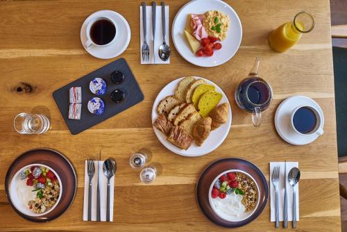 a wooden table with plates of breakfast food on it at Regno Di Morea in Nafplio