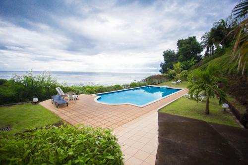 a swimming pool with a view of the ocean at Appartement standing 2 chambres vue mer RES TAHIRI 3 in Punaauia