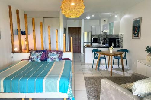 a bedroom with a bed and a living room at Grand Studio Les Horizons Papeete in Papeete