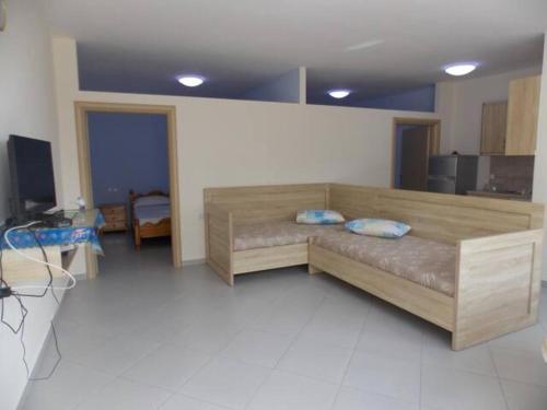 - un salon avec un canapé en bois dans l'établissement Vasili Apartments, à Saranda
