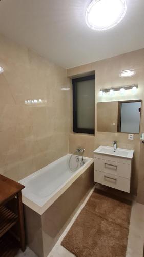 a bathroom with a bath tub and a sink at Vila FERIE in Nová Lipnica