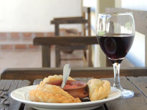 un plato de comida y una copa de vino en El Rancho de Manolo en Molinos