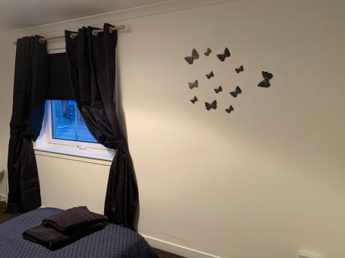 a bedroom with butterflies on the wall at Dumfries Apartment in Dumfries