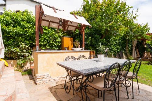 a table with chairs and an umbrella on a patio at B&B La Dolce Vita in Flumini di Quartu