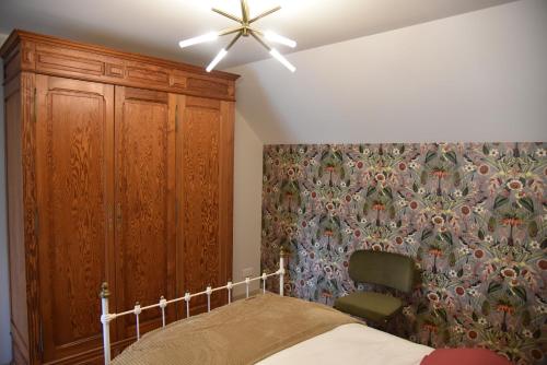 um quarto com uma cama e um armário de madeira em Au Relais de Laborde em Saint-Germain-les-Vergnes