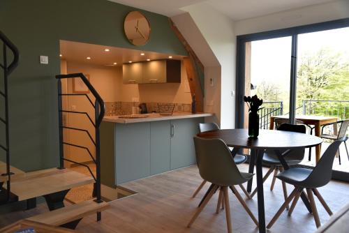 une cuisine et une salle à manger avec une table et des chaises dans l'établissement Au Relais de Laborde, à Saint-Germain-les-Vergnes