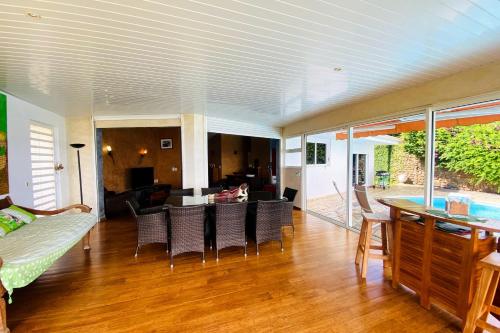 a living room with a couch and a table and chairs at Villa Bounty - amazing ocean view in Punaauia
