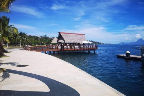 a pier with a restaurant on the water at Recent Bel Appartement une chambre Papeete in Papeete