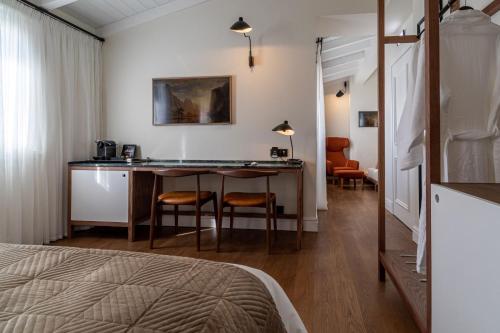 um quarto com uma cama, uma mesa e cadeiras em Regno Di Morea em Nafplio