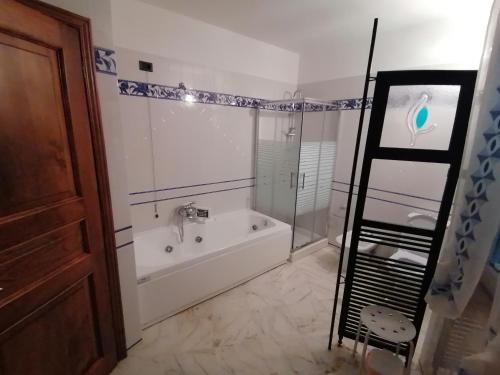 a bathroom with a tub and a glass shower at IL CASALE DEL MAGRA in Ameglia