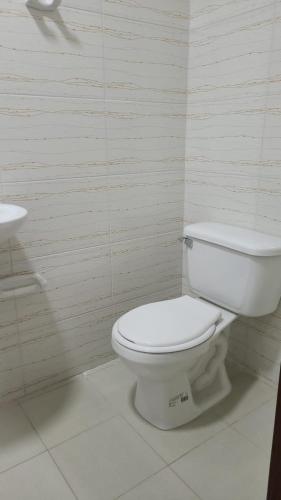a bathroom with a white toilet and a sink at Edificio Tony - Alojamiento Aparta-Hotel in Barrancabermeja