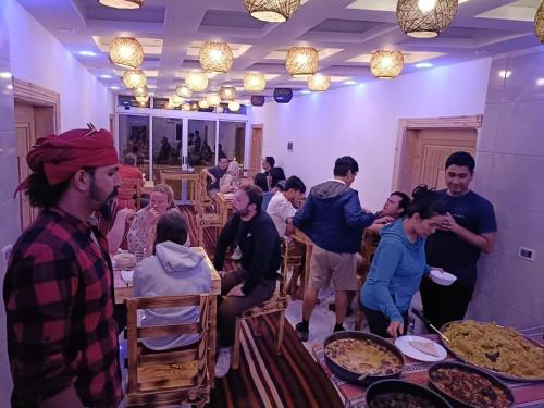 a group of people standing around a table with food at Petra Desert Dream Hotel in Wadi Musa