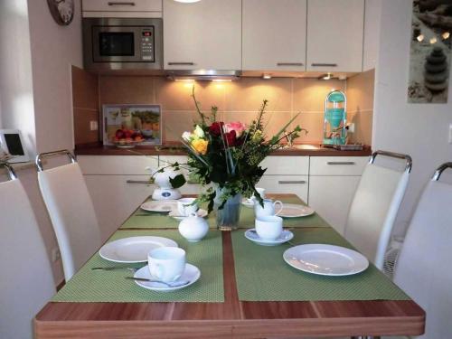 a dining room table with plates and flowers on it at Dünendomizil strandnah in Bansin