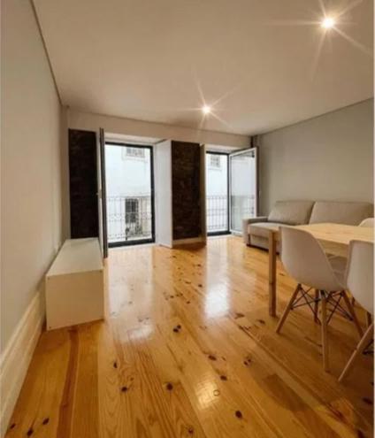 un soggiorno con un tavolo e un divano di São Bartolomeu Apartment 2 a Coimbra