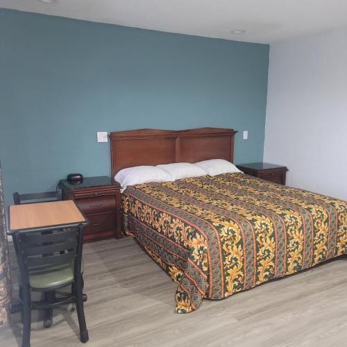 a bedroom with a bed and a desk and a chair at Economy inn in Corning