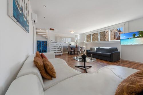 Villa Homa في دوبروفنيك: غرفة معيشة مع أريكة بيضاء وطاولة