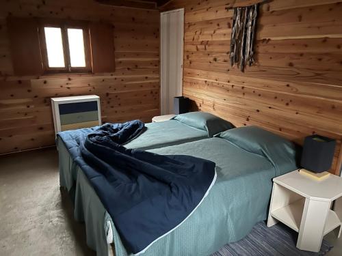 una camera da letto con un grande letto in una camera in legno di A Cabana ad Angra do Heroísmo