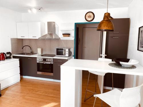 una cucina con armadi bianchi e piano di lavoro bianco di Schickes Appartement in Wuppertal-Ronsdorf Whg. 66 a Wuppertal