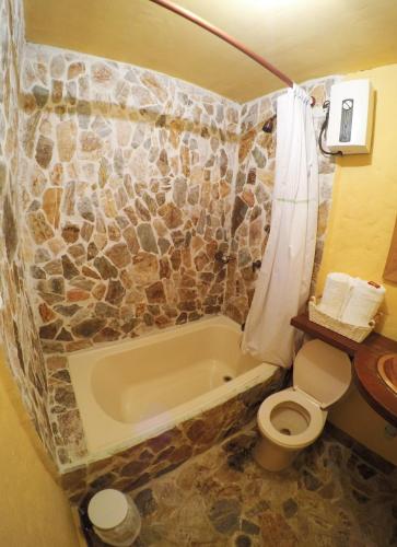 a bathroom with a toilet and a bath tub at Finca Turística de Alojamiento Rural Avalon in Jardin