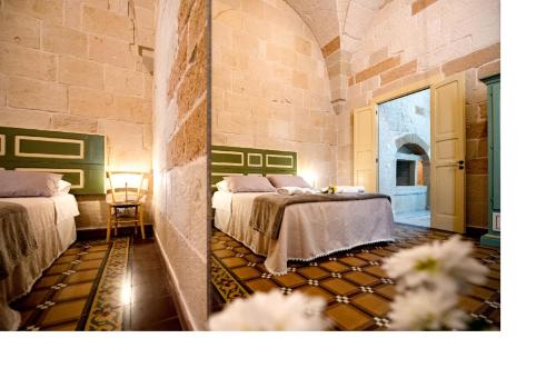 a bedroom with two beds and a room with flowers at MIOE in Muro Leccese