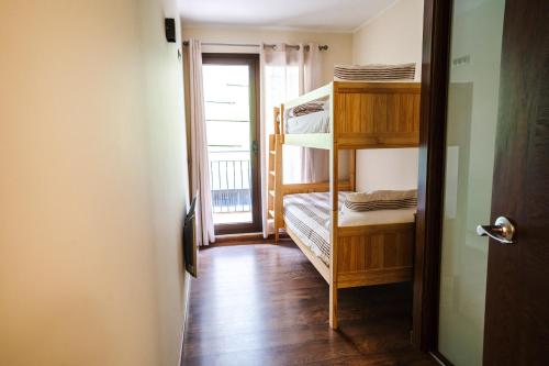 Zimmer mit Etagenbetten und einer Tür mit Fenster in der Unterkunft Apartamento Luxury en Bordes d'Envalira, Andorra in Soldeu