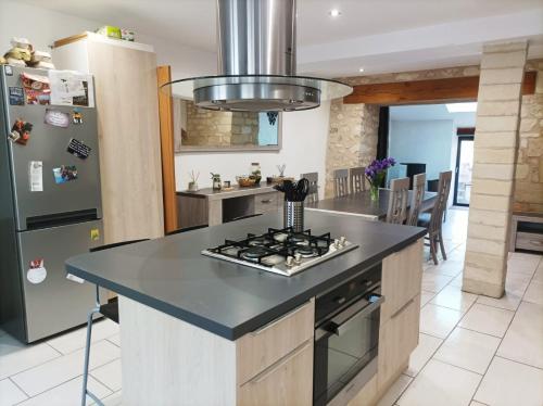 une cuisine avec une cuisinière et un réfrigérateur dans l'établissement Agréable maison de ville tout confort, à Loudun