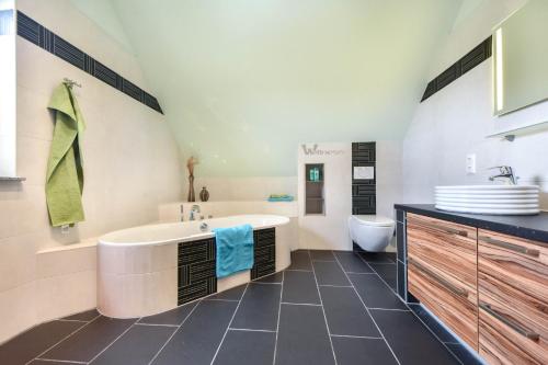 a bathroom with a tub and a sink and a toilet at Ferienhaus Benzer Höh in Benz