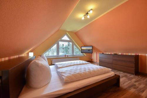 a bedroom with a large bed in an attic at Ferienhaus Benzer Höh in Benz