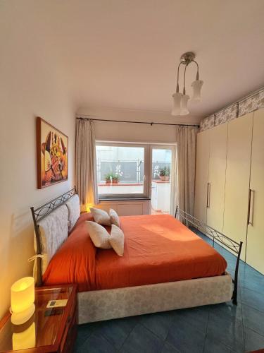a bedroom with a large orange bed with a window at Augusto Capri Apartment in Capri