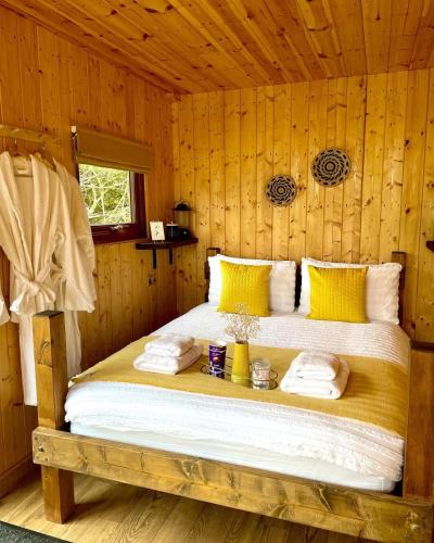 a bedroom with a bed in a wooden room at Trethowels Hidden Huts in St Austell