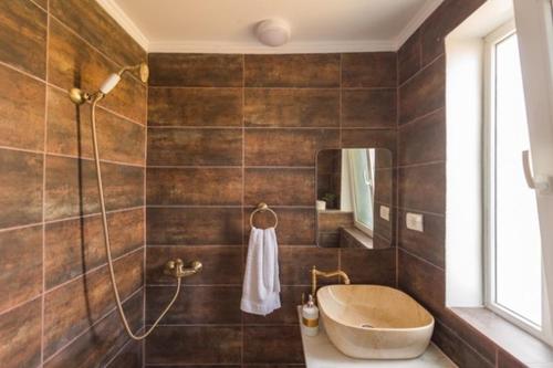 a bathroom with a tub and a sink and a mirror at Vila Troia Vama Veche in Vama Veche