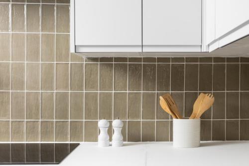 a kitchen counter with a vase with wooden utensils at Luxe Design - Boutique Apartment - Heart of Rothbury in Rothbury