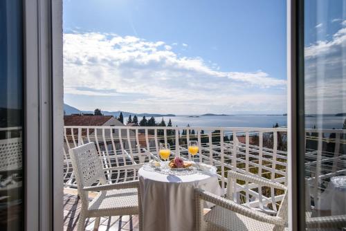 a table with two glasses of wine on a balcony at Aurora Seaview Apartment in Mlini